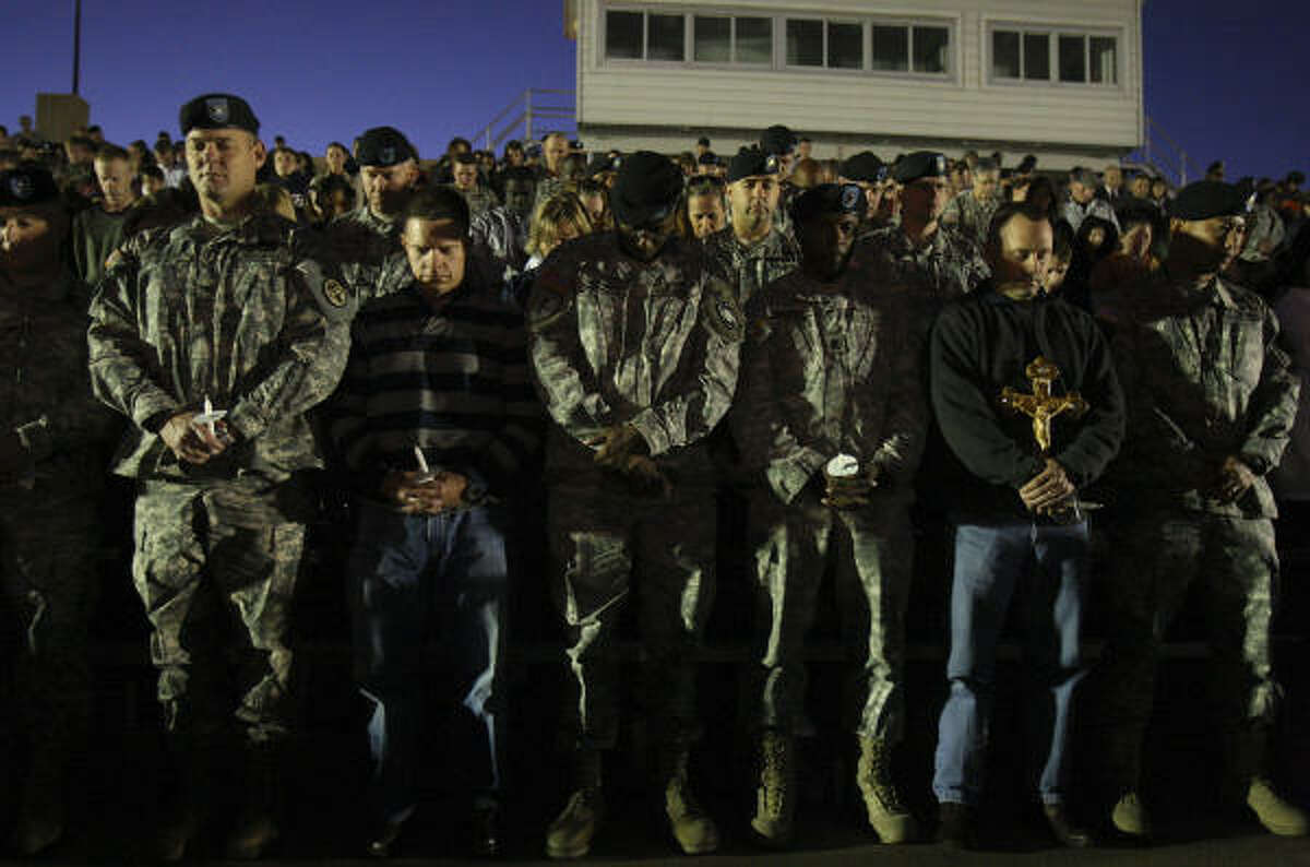 People pray during a candlelight vigil held at Hood Stadium on Friday.