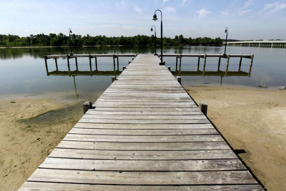 Sandbars loom Friday around a pier at Kingwood's Kings Harbor, where Lake Houston's water level shows the lack of rain. Since February, the area has gotten about as much as the Sahara.