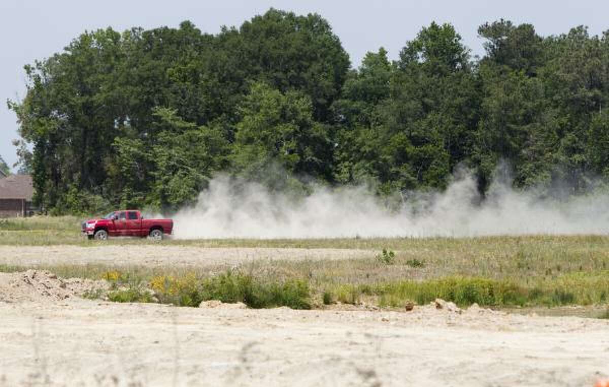A truck kicks up dust as it drives through a dry field Friday in Spring.
