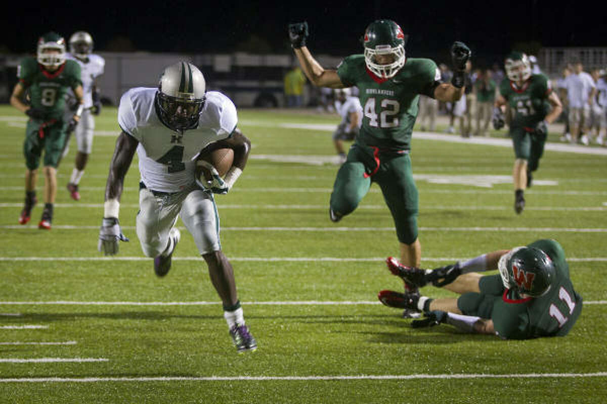 Hightower's Ed'Marques Batties (4) leaves a pair of The Woodlands defenders while going in for a first-half touchdown.