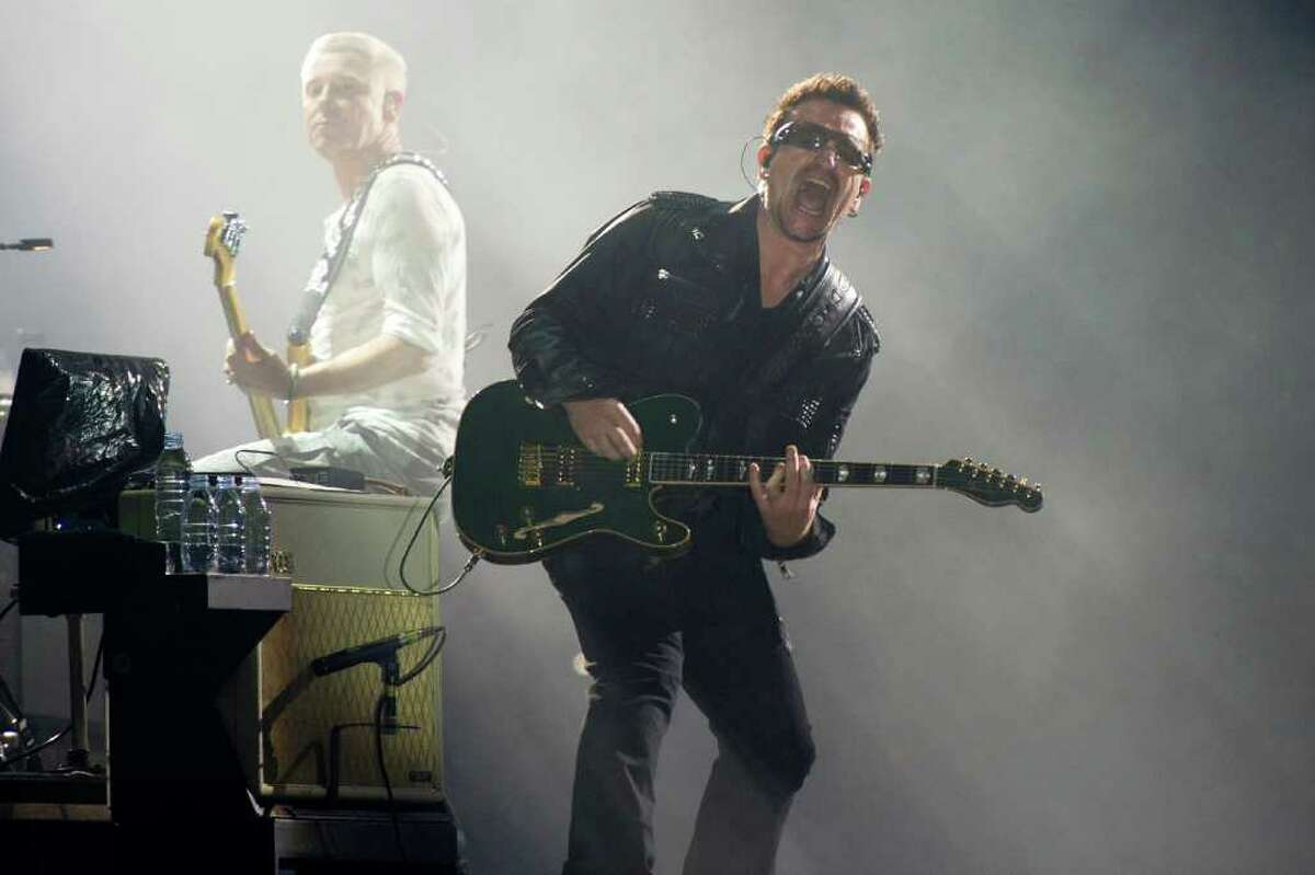 FILE - In this July 20, 2011 file photo, Bono, right, and Adam Clayton, from the rock group U2, perform in concert as part of U2?s 360 Tour at the New Meadowlands Stadium in East Rutherford, N.J. Toronto International Film Festival organizers say they will launch Sept. 8 with "From the Sky Down," a chronicle of the Irish band led by singer Bono. The film was made by "An Inconvenient Truth" director Davis Guggenheim and marks the first time in its 36-year history that the Toronto festival has opened with a documentary. (AP Photo/Charles Sykes, file)