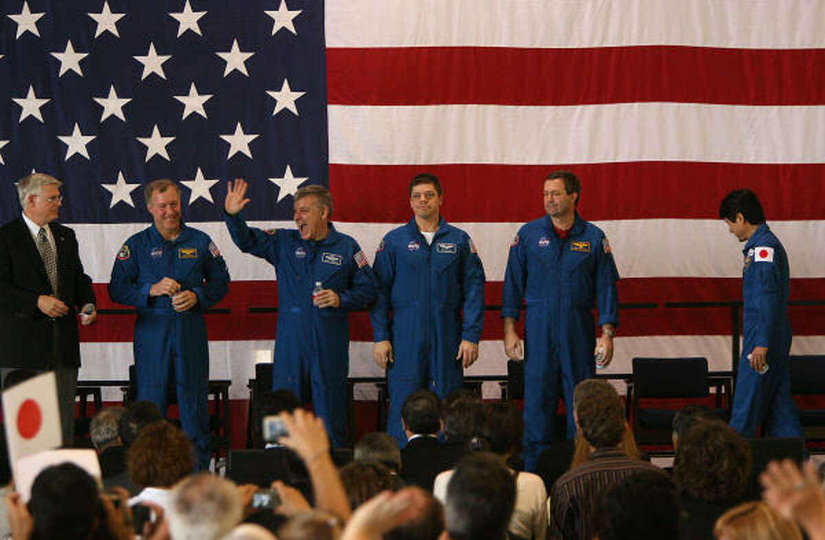 Commander Dominic Gorie, pilot Gregory H. Johnson, Robert Behnken, Mike Foreman and Japanese astronaut Takao Doi walk on stage to a cheering crowd.
