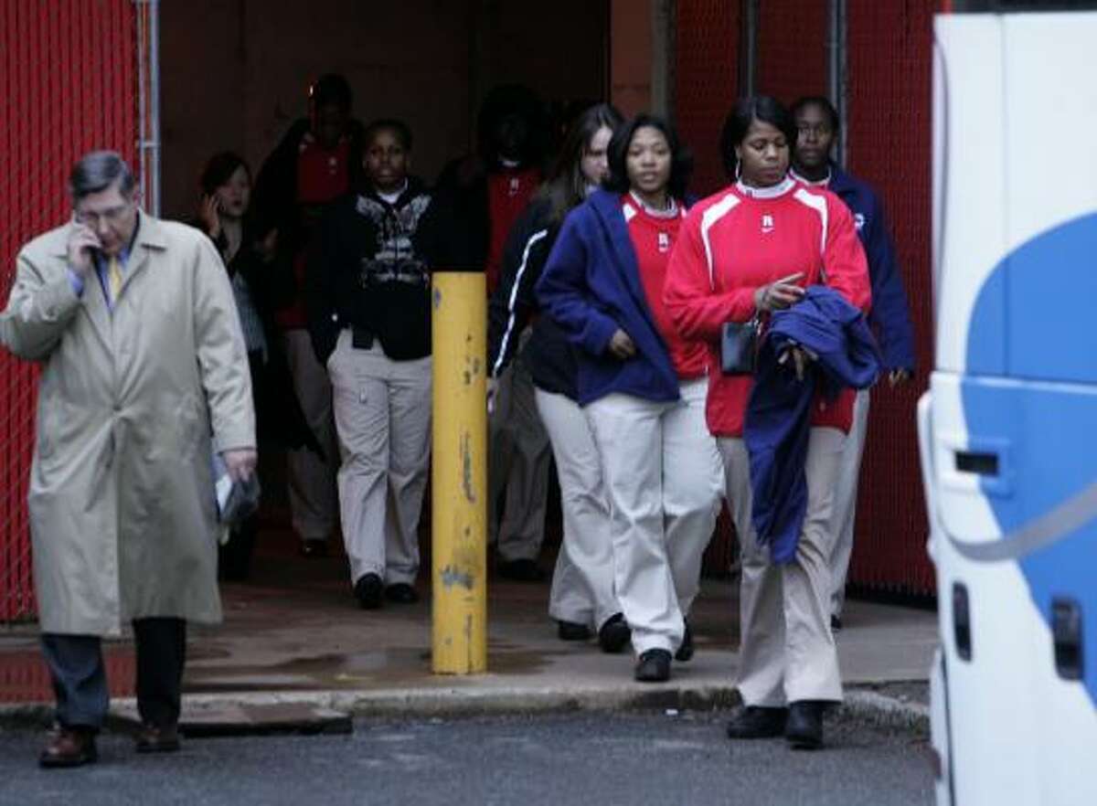 Accompanied by Athletic Director Robert Mulcahy, left, members of the Rutgers University women's basketball team head to a bus in Piscataway, N.J., to be driven to a meeting with radio host Don Imus.