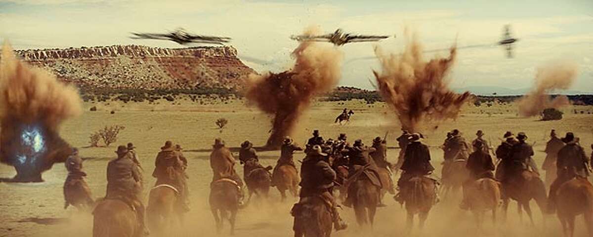 Cowboys fight for their lives in the desert, pursued by spaceships in "Cowboys & Aliens." UNIVERSAL STUDIOS