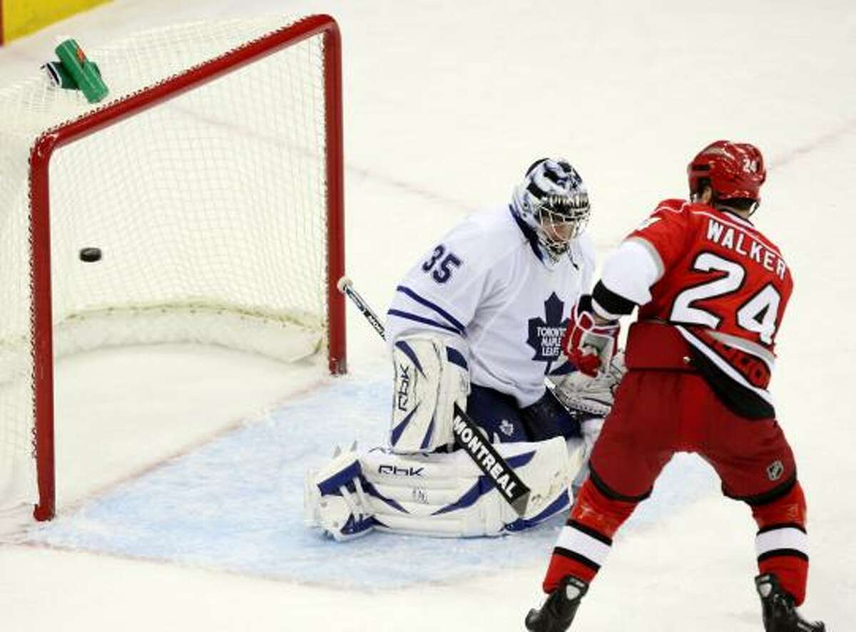 Camped just outside the crease, the Hurricanes' Scott Walker is in position to tip a shot past Maple Leafs goalie Vesa Toskala for the winning goal in overtime.