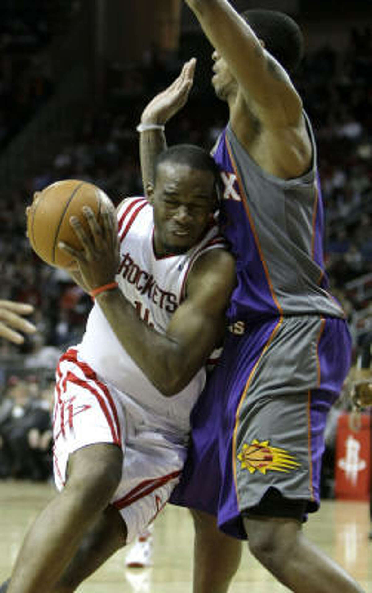 Rockets forward Carl Landry is fouled as he runs into Suns center Channing Frye during the fourth quarter.