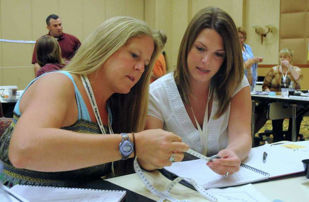 Rachelle Varnon, Houston ISD's St. George Place 4th grade teacher, and 5th grader teacher Melissa O'Donnell, of Austin, measure a string they will use for a pendulum making project during the Houston Mickelson ExxonMobil Teachers Academy at The Woodlands Resort & Conference Center. Over 200 elementary school teachers from across the country are attending the Academy to hone their skills in math and science teaching. The Academy is designed to equip teachers with innovative tools to teach their students math and science. Photo by David Hopper.