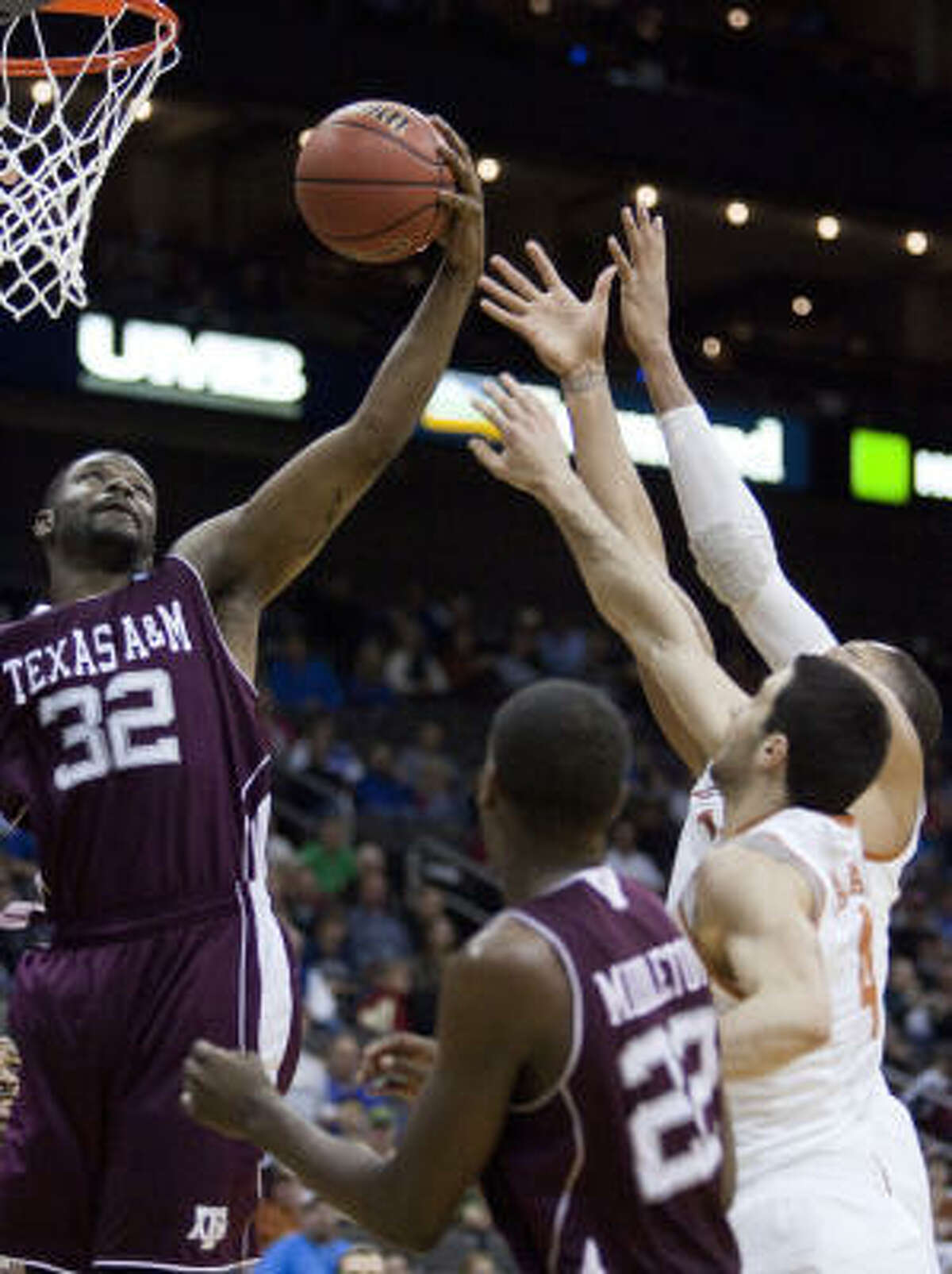 Texas A&M's Kourtney Roberson (32) grabs a rebound in front of teammate Khris Middleton (22) and Texas' Dogus Balbay (4) aTristan Thompson in the second half.