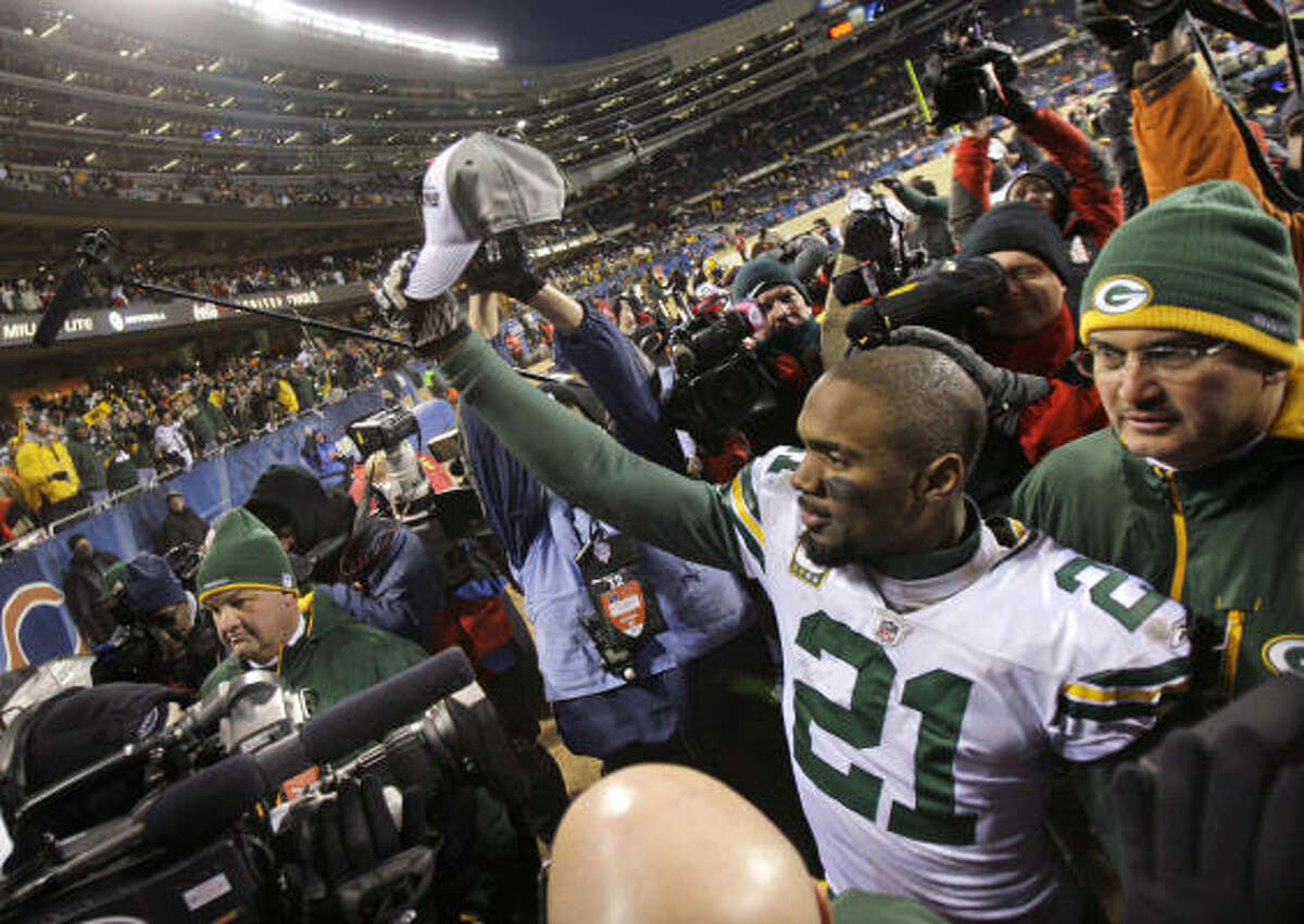 Packers cornerback Charles Woodson holds up an NFC championship cap after Green Bay's win over the Bears in Sunday's NFC championship game at Soldier Field in Chicago. The Packers are heading to the Super Bowl for the first time since 1997.