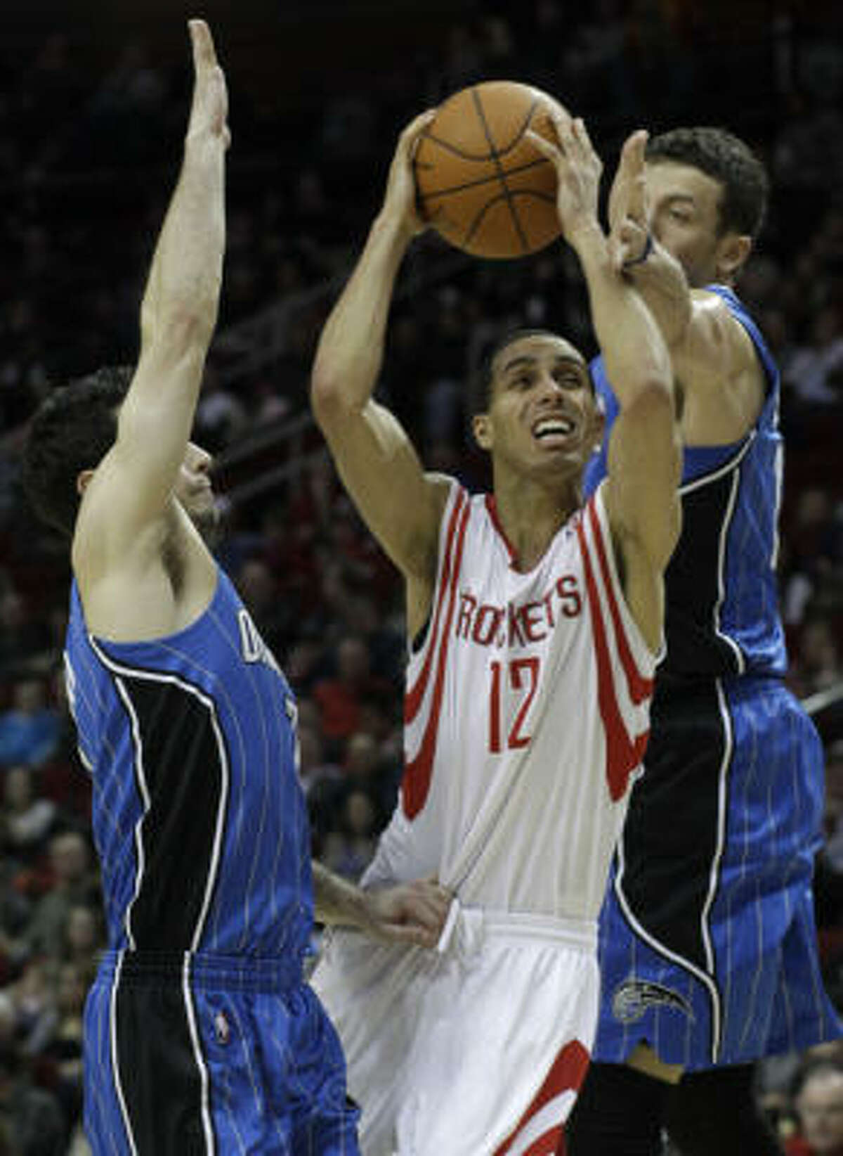 Rockets guard Kevin Martin (12) runs into Orlando's J.J. Redick and Hedo Turkoglu during the second half. Martin finished with 18 points.
