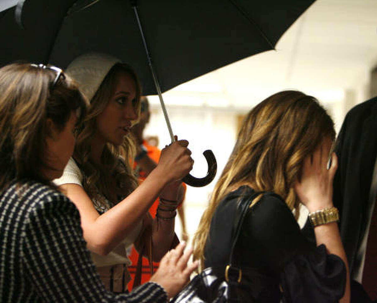 Celebrity siblings Haylie, center, and Hilary Duff, right, tried to avoid the media when they left a Harris County family court in December 2007.