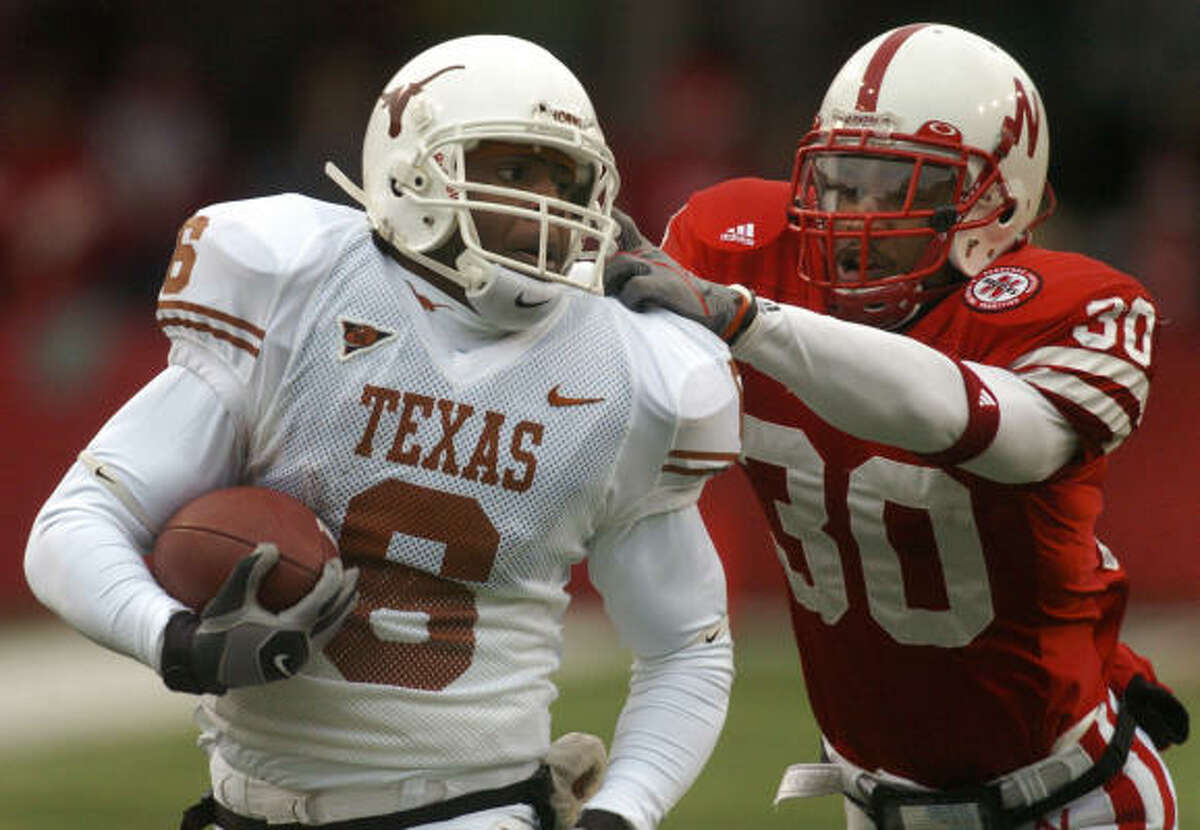 Texas wide receiver Quan Cosby is stopped from behind by Nebraska safety Tierre Green.
