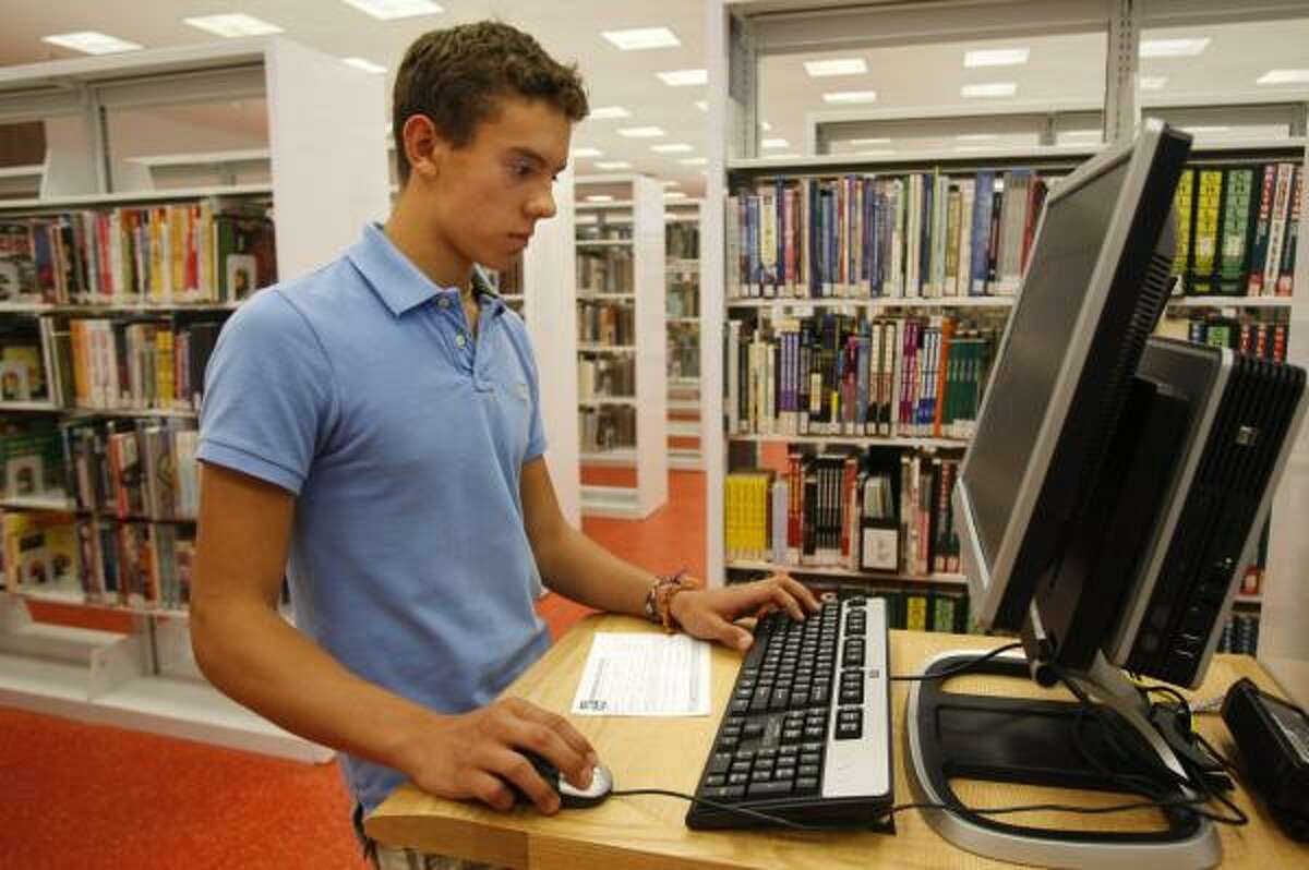 Clevin Cevallos, 14, searches for a book on one of the many upgraded computers at the library.