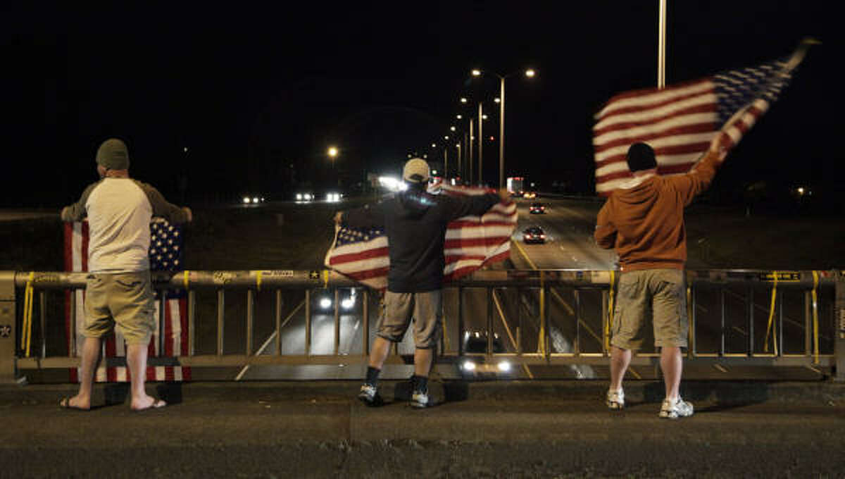 People cheer and wave flags on the "Freedom Bridge" just outside Joint Base Lewis-McChord near Tacoma, Wash., after they heard the news that Osama bin Laden had been killed.