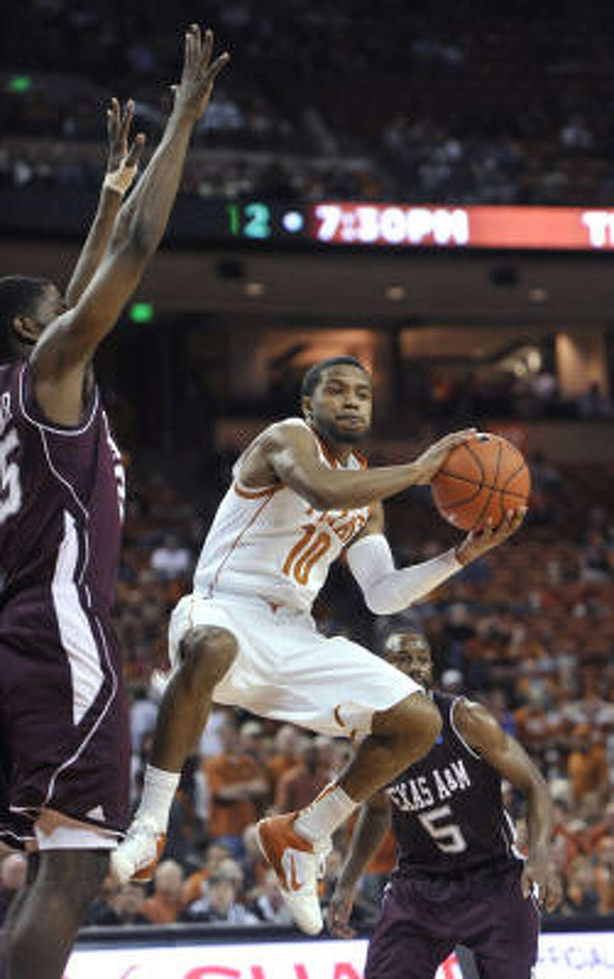 Texas guard Jai Lucas looks to pass as Texas A&M forward Ray Turner, left, defends during the second half.