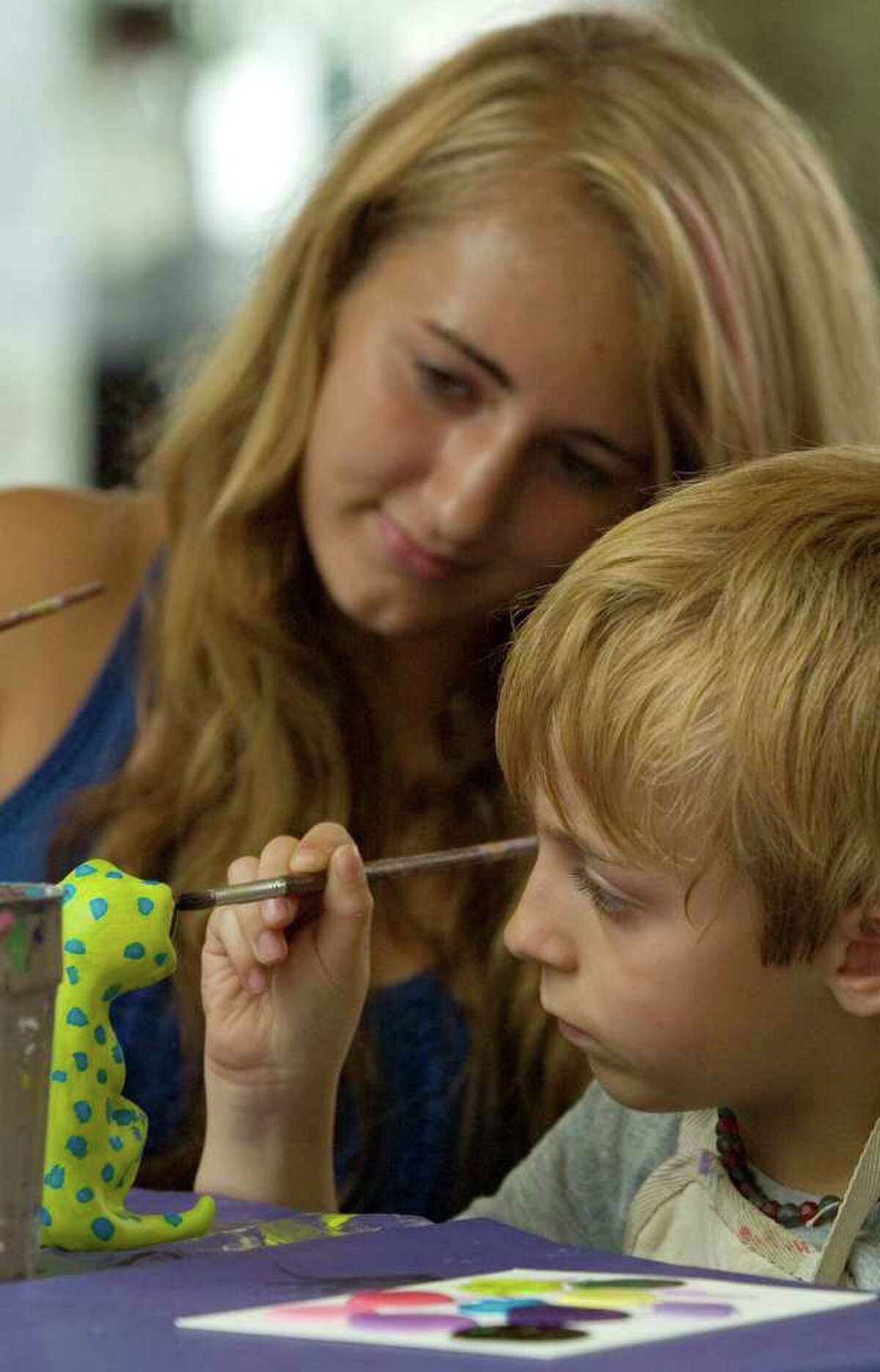 Skyler Cary, 7, right, and his sister Summer Cary, 15, paint a lizzard sculpture at the Village Center for the Arts booth during the 44th Annual New Milford Village Fair Days on Friday, July 29, 2011.