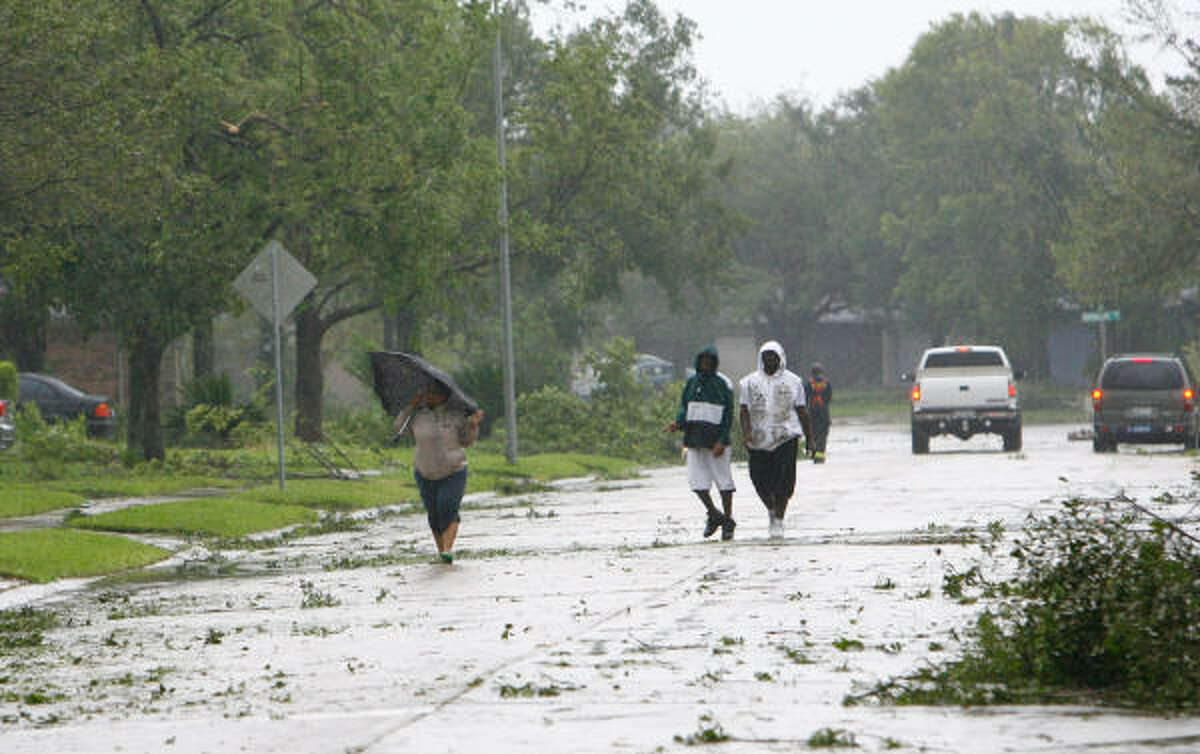 People walk to assess neighborhood damage in Pearland this morning after Hurricane Ike made landfall. Harris County Judge Ed Emmett urged residents to stay in their homes and conserve water today as officials assess the damage dealt by Ike.