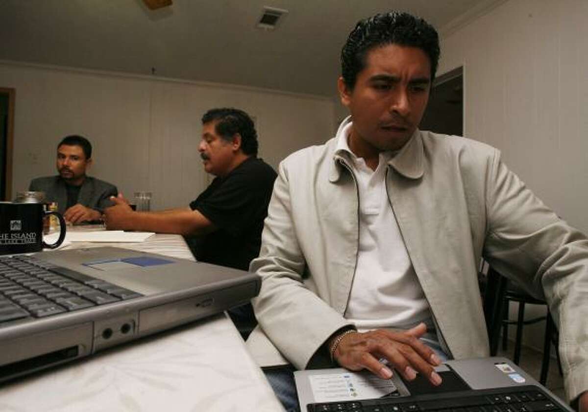 Edgar Diaz checks notes on his laptop as he and business partners Antonio Hernandez, left, and Jose Luis Martinez discuss plans to start a feedlot in San Luis Potosí.