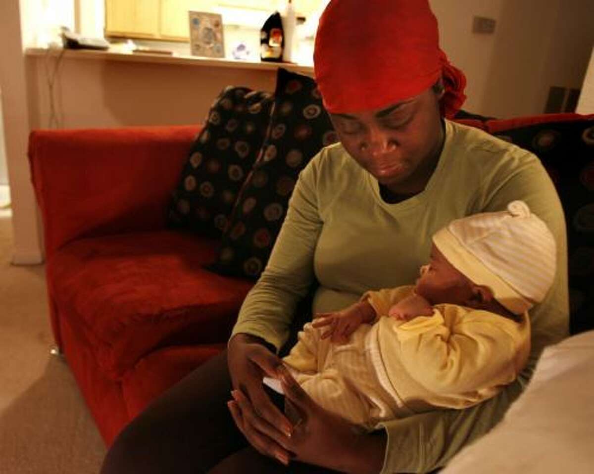 Kim Hines holds one-month-old daughter Kynadi La'Nae on Wednesday night and mourns the death of her husband, Jerry, who was killed while assisting motorists on U.S. 59.