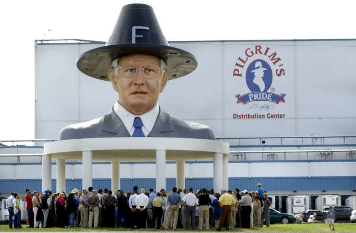A group gathers under the 40-foot-tall bust of Bo Pilgrim for the dedication of a distribution center in 2002.