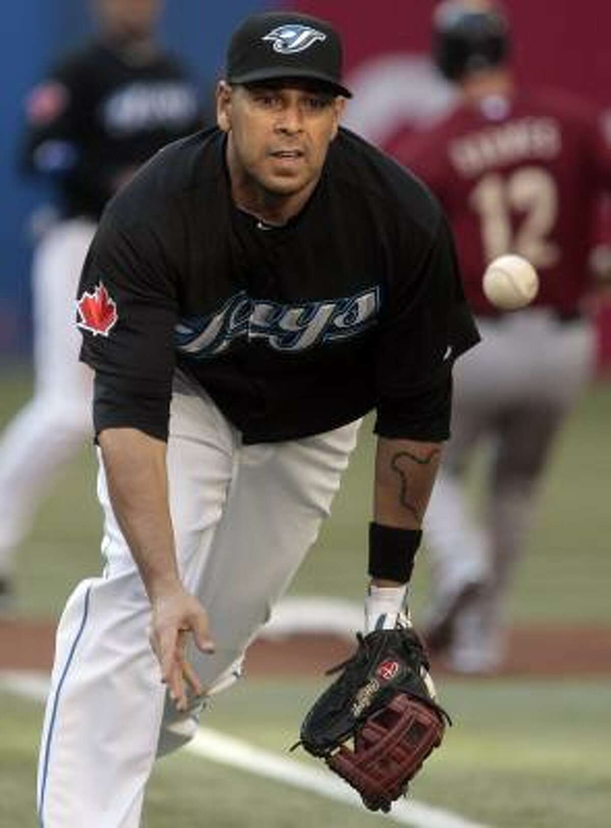 Blue Jays first baseman Juan Rivera makes a play for an out at first base.