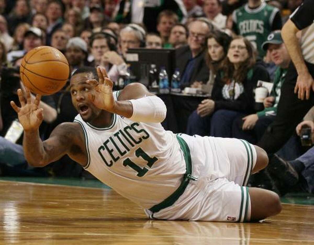Celtics forward Glen Davis passes the ball after he knocked it away from Rockets power forward Patrick Patterson.