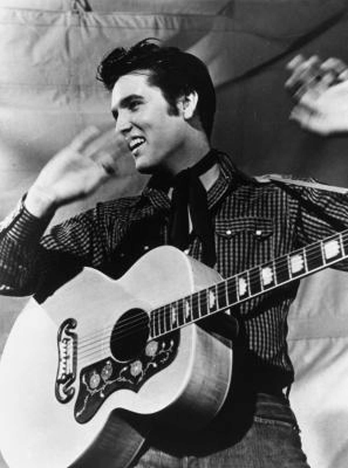 Presley is shown with his Gibson J-200 guitar in 1957.