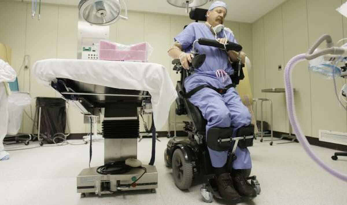 Gene Alford rises to a standing position in a wheelchair in April during a visit to a Methodist Hospital surgical suite.
