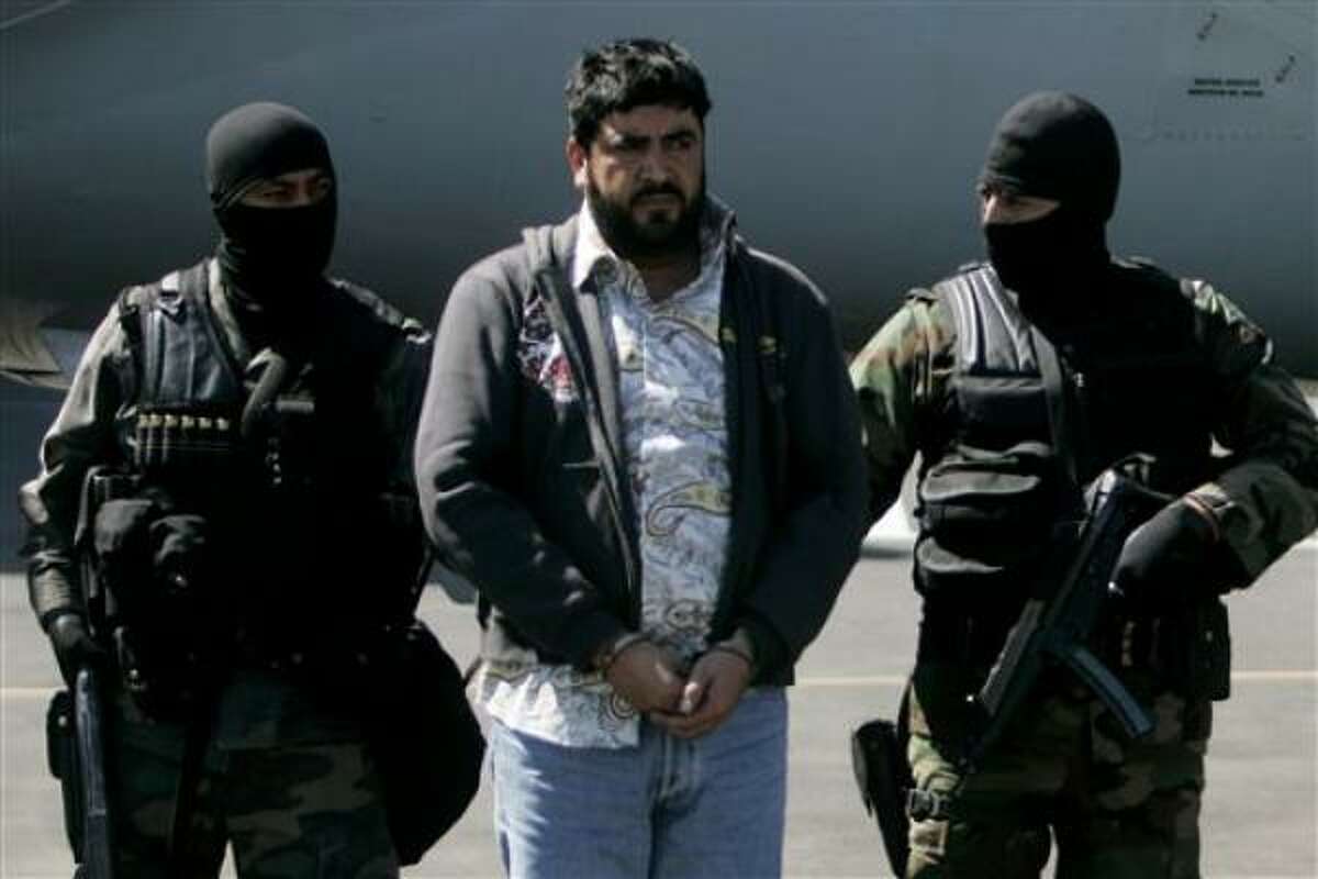 Mexican federal police officers escort Alfredo Beltran Leyva, known as El Mochomo, Monday at Mexico City's airport.