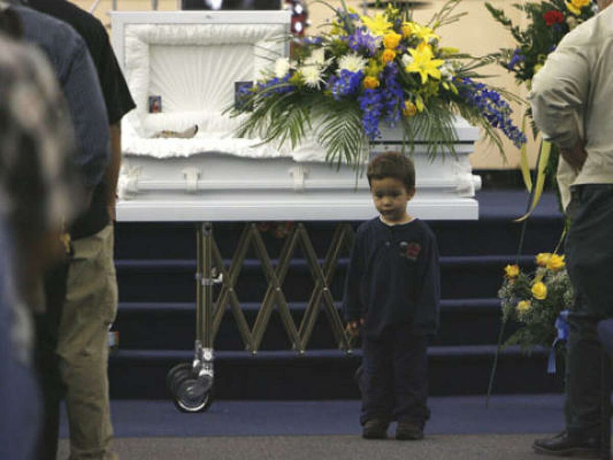 Peter Rios, 2, stands near his older brother during a memorial service Friday for Pedro Rios at the Bethel Christian Center in Pasadena. The 4-year-old died Tuesday after being mauled by two pit bulls outside his home. Peter escaped the attack.