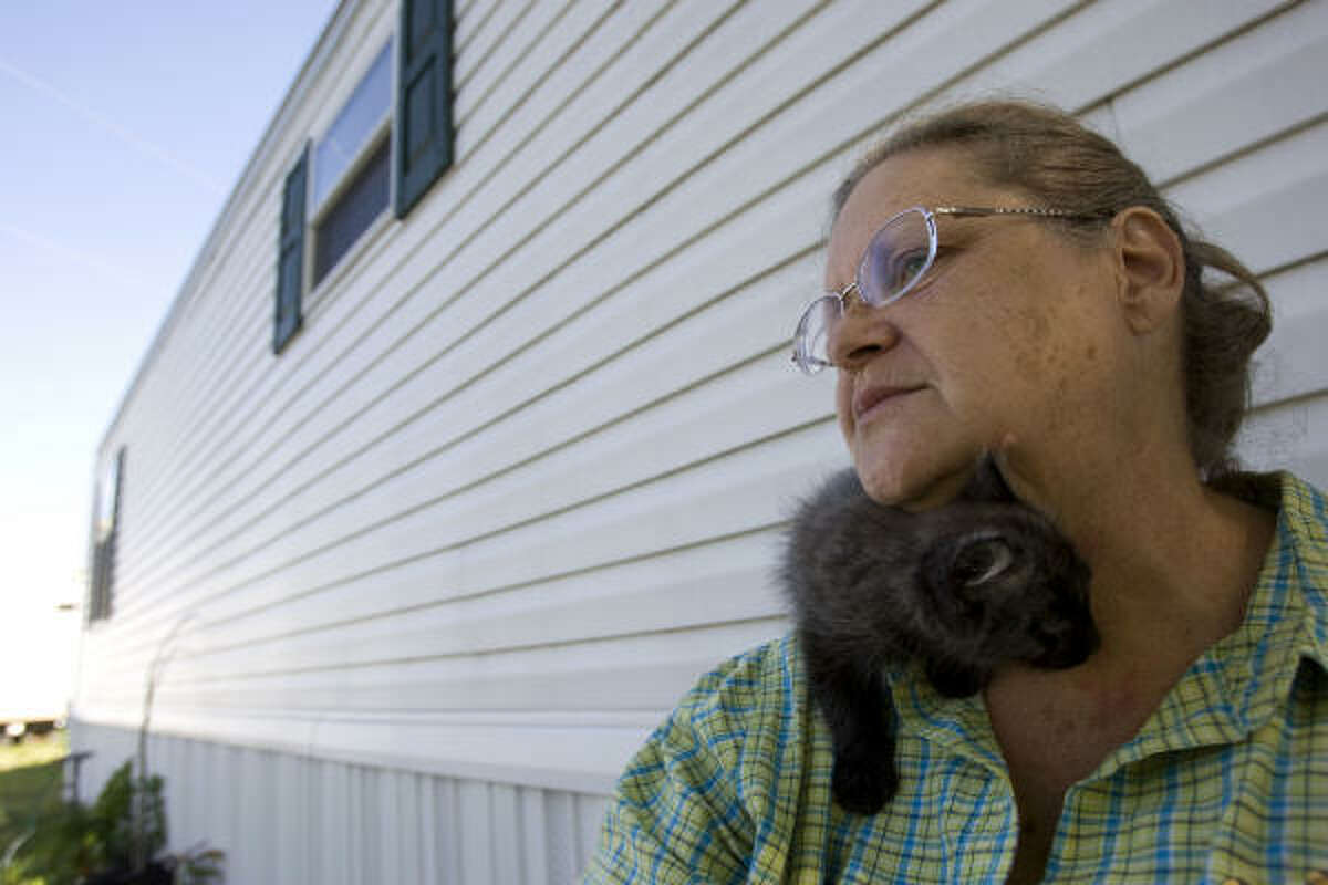 Mary Shosty and her cat Bella relax outside the FEMA mobile home she shares with her husband, L.J., in San Leon. The couple said they were happy with FEMA's response to Hurricane Ike.