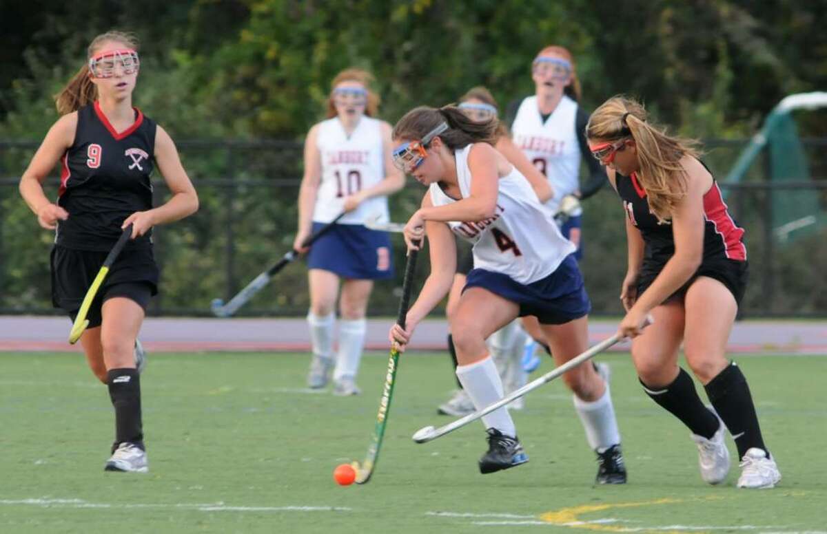 Alli George, #4, of Danbury High School, Danbury, CT controls the ball as Molly Brachfeld,#9, left and Stacey Dileo, #11, right, of Warde High School in Fairfield, CT try to make the steal on Thursday, Oct. 1, 2009 at the girls field hockey game at Danbury High School.