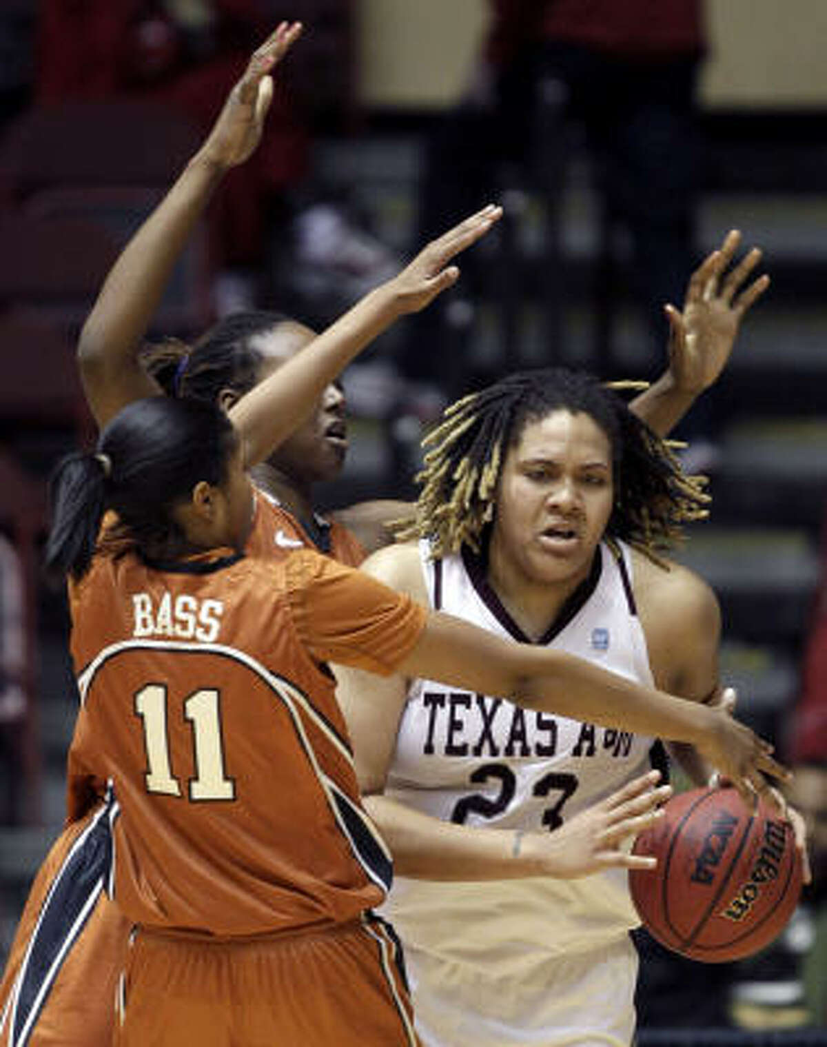 Texas A&M's Danielle Adams tries to find her way around Texas' Chelsea Bass, left, and Ashley Gayle.