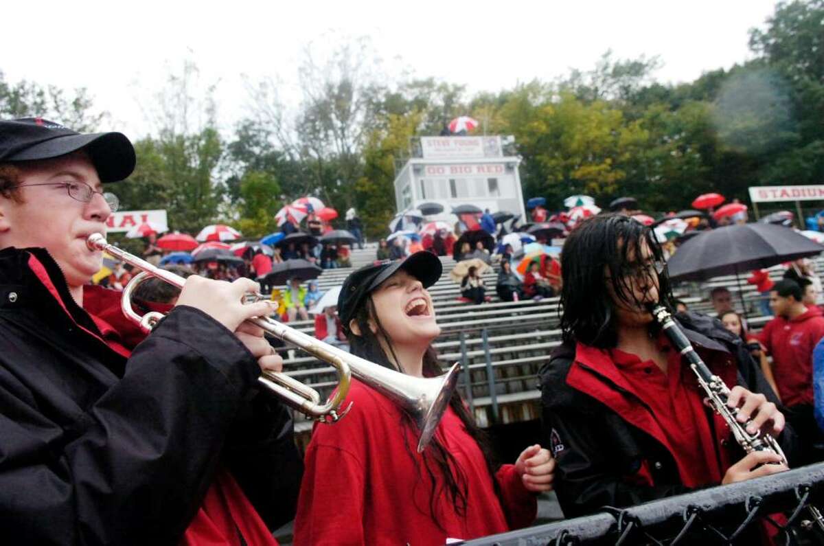 Though the rest of the band packed up their instruments, Warren Bein, left, Jessica Rehberger and Michael Napoli hangtough as they join the cheerleaders for "Hey Baby" as the Greenwich High football team hosts Harding High School for the Greenwich Homecoming game Saturday afternoon, Oct. 3, 2009.