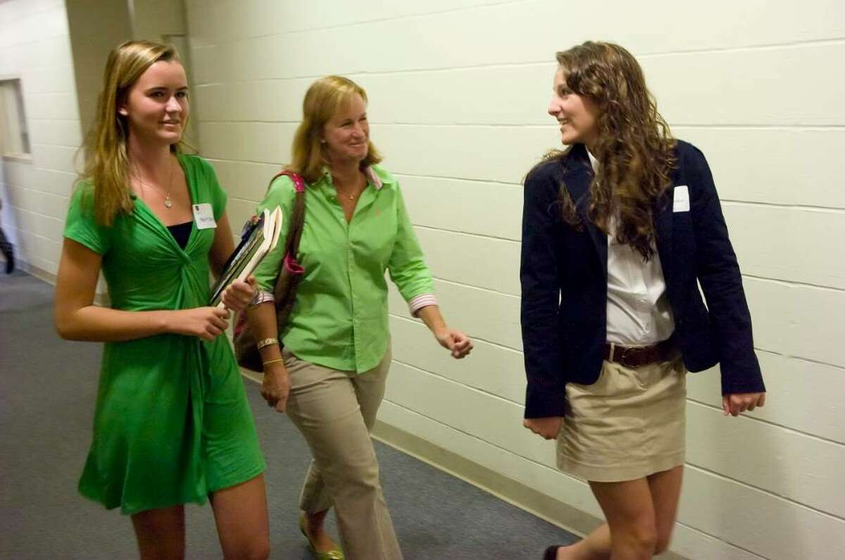 King school sophomore Kaleen (cq) Sullivan, 15, right, escorts Kylis GLover, 15, left, and her mom Diane Glover, center, to the gym during an open house at the King school in Stamford, Conn. on Sunday, Oct. 4, 2009.