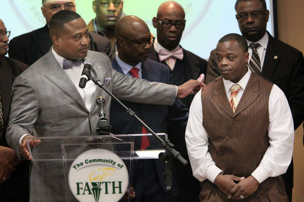 Quanell X, left, on Thursday introduces Henry Lee Madge, 27, who says he was attacked by a Houston police officer for no reason and that he lost his job because of the incident.