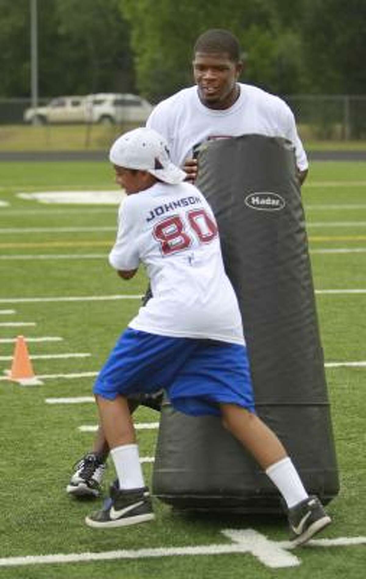 A participant in the Andre Johnson youth camp Saturday at Fort Bend Baptist Academy finds the Texans wide receiver is difficult to budge.