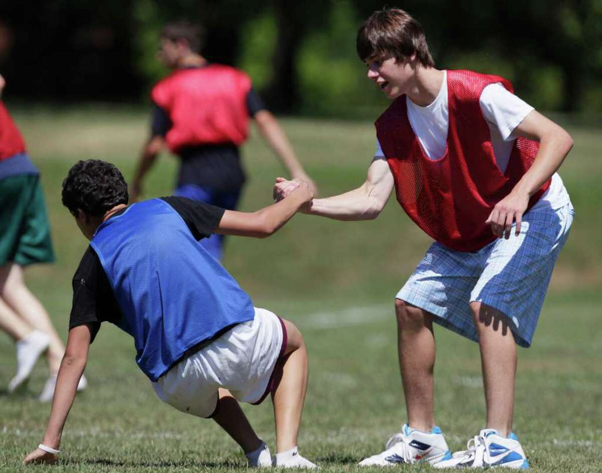 Connor Murphy of the US, right, gives a hand up to Isaac Otherman of Palestine during a soccer game at Project Common Bond on the Foxcroft School campus in Middleburg, Va., Wednesday, July 27, 2011. Project Common Bond brings together offspring of 9/11 victims with other teens who have lost family members to acts of terror around the world. (AP Photo/Carolyn Kaster)