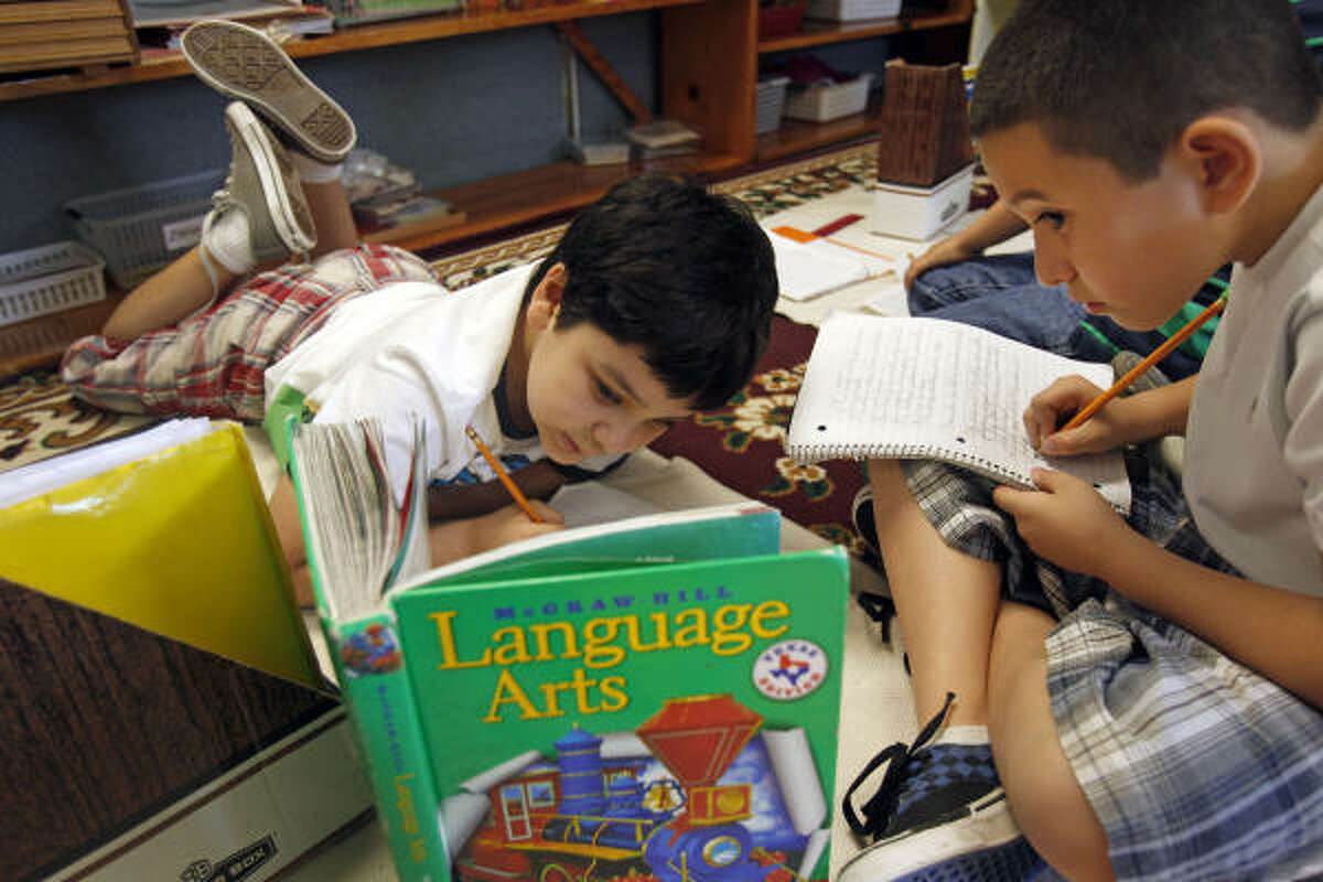 Diego Patron, left, and Michael Martinez, both 9, work on a punctuation lesson at Alief Montessori Community School. Of the top 10 local elementary schools, the school has one of the lowest per-pupil spending amounts, according to state data.