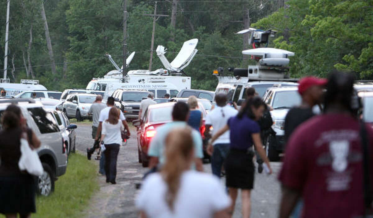 Local and national media return to their vehicles after Capt. Rex Evans of the Liberty County Sheriff's Department said dead bodies weren't found.