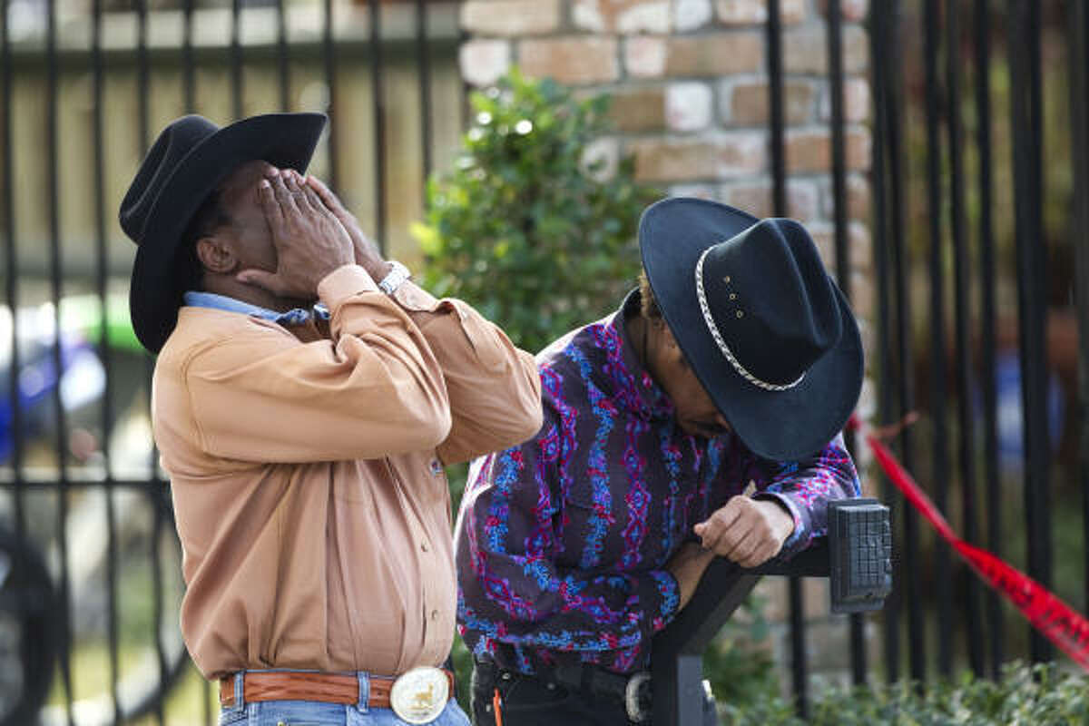 Anthony Sanders, left, and Oliver "Tony" Sanders, husband of one of the two women who perished in a deadly three-alarm fire, react as the last of the two bodies were recovered from the house Wednesday.