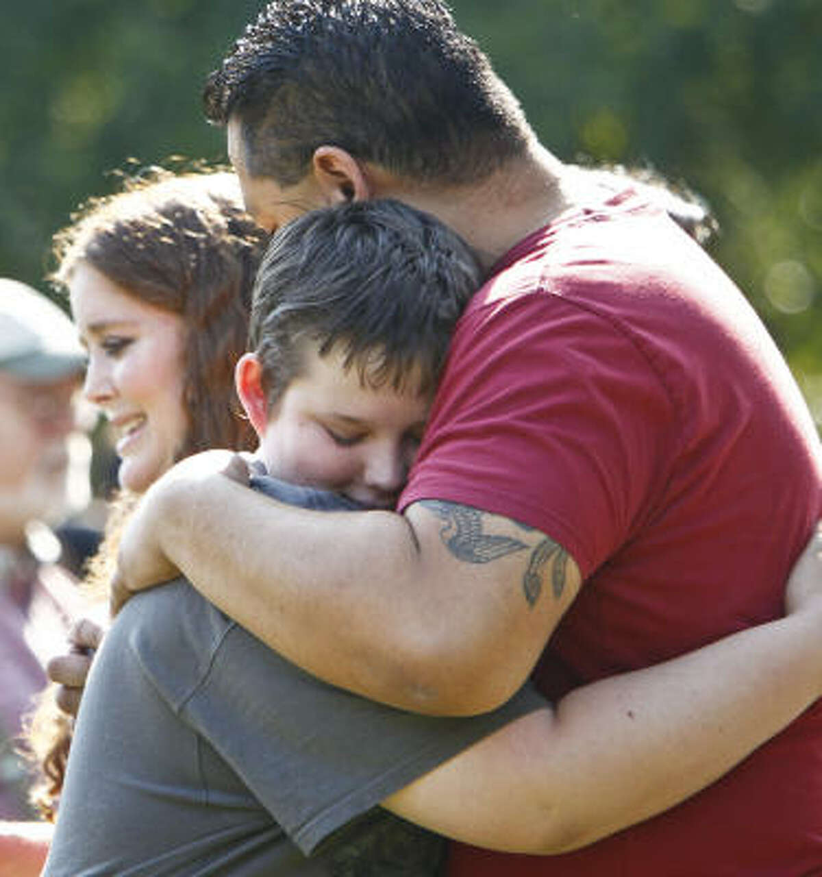 Braydon Young ,14, a classmate and friend of Asher Brown, gets a hug from David Truong, the stepfather of the young suicide victim, during the Saturday memorial service.