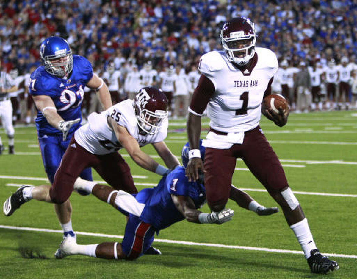 Texas A&M quarterback Jerrod Johnson gets past Kansas safety Lubbock Smith for a touchdown during the first half on Saturday night.
