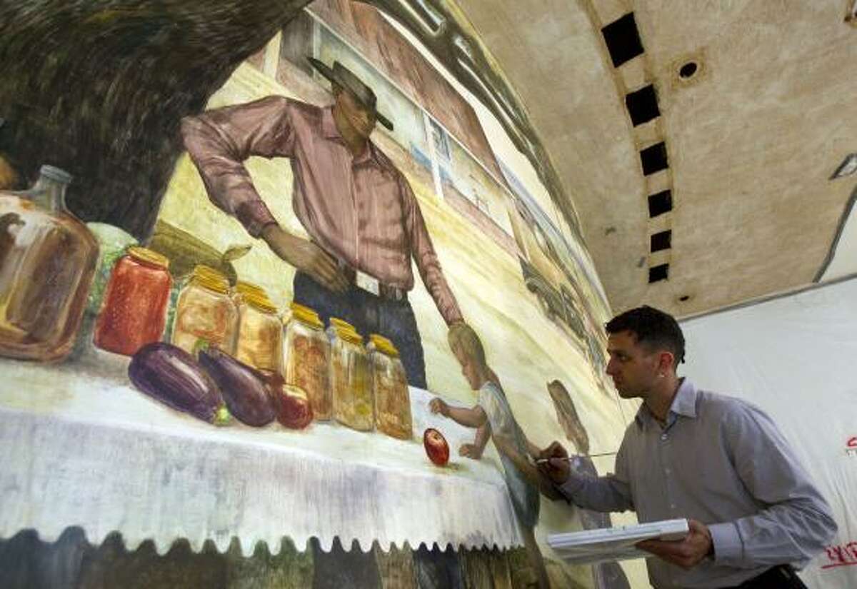 Kuvalesaya Zakheim works on restoring the fresco — painted in 1952 by Peter Hurd — in the foyer of the M.D. Anderson Cancer Center administration building.