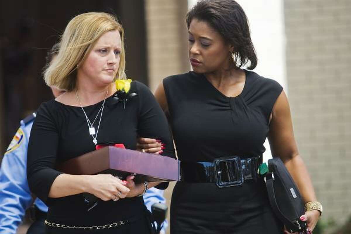 Nikki Araguz, left, leaves the Wharton Civic Center after the July 12 funeral of her husband, Thomas Araguz III.