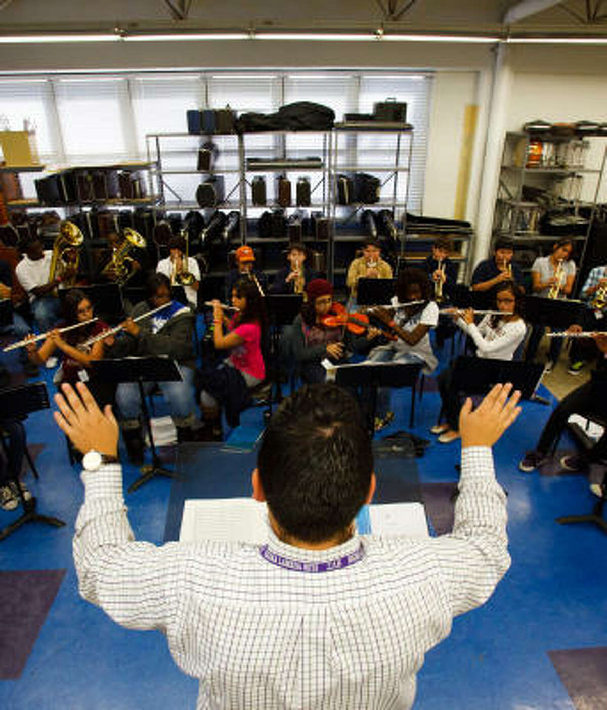 Band Director Eric Jimenez takes his Hamilton Middle School symphonic band students through their paces. When some students couldn't afford to buy instruments, he sent out e-mails soliciting instruments and applied for grants.