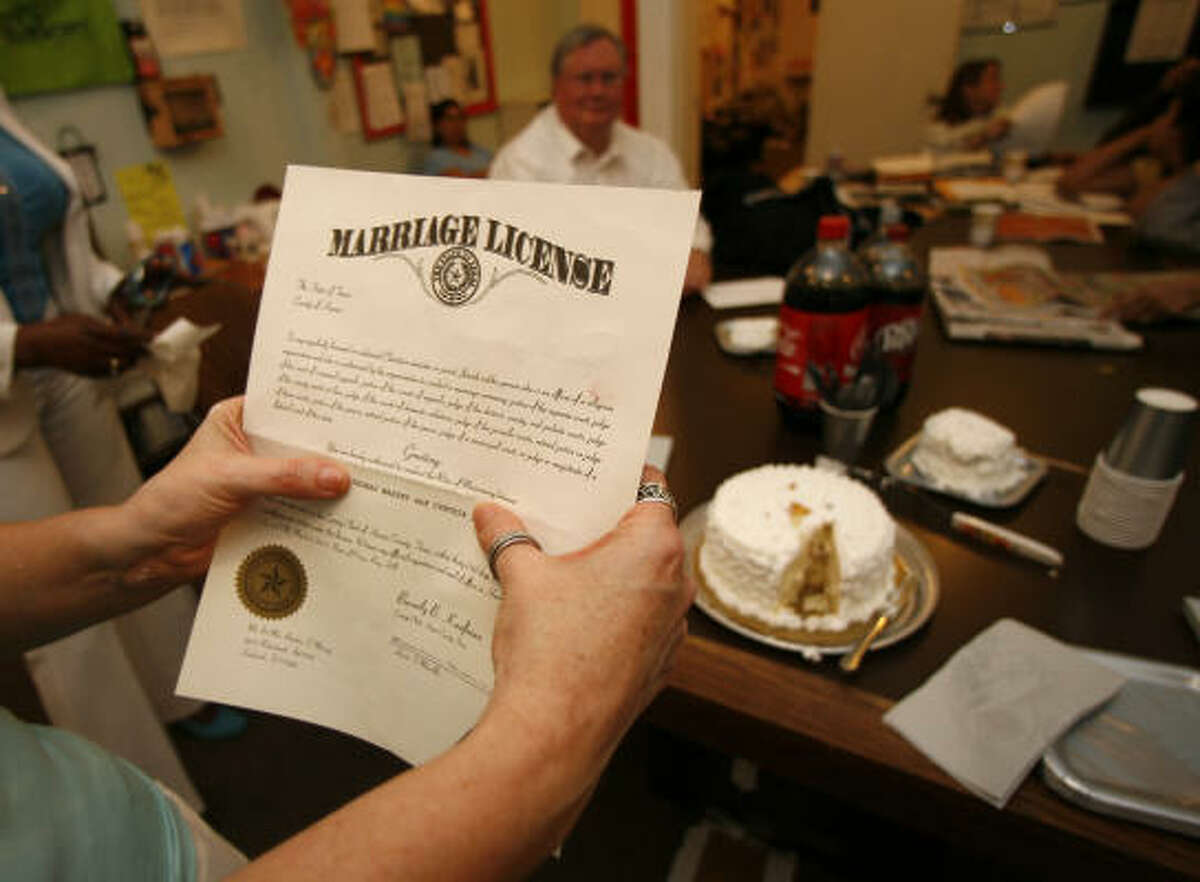 “Mrs. Massey” holds her marriage license at her wedding reception in the KPFT lunchroom.