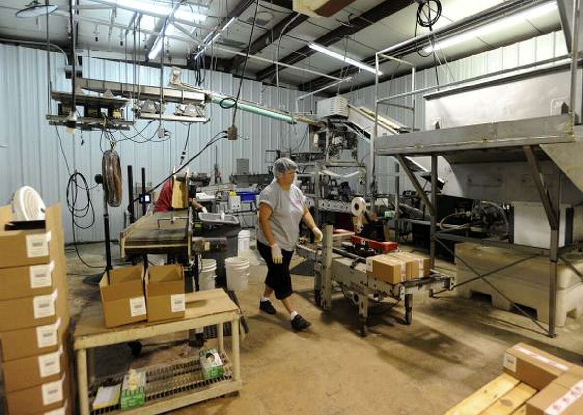Maria Calloway works in the processing area of Texas Tito's in New Braunfels. The pepper company is expanding into pickles.
