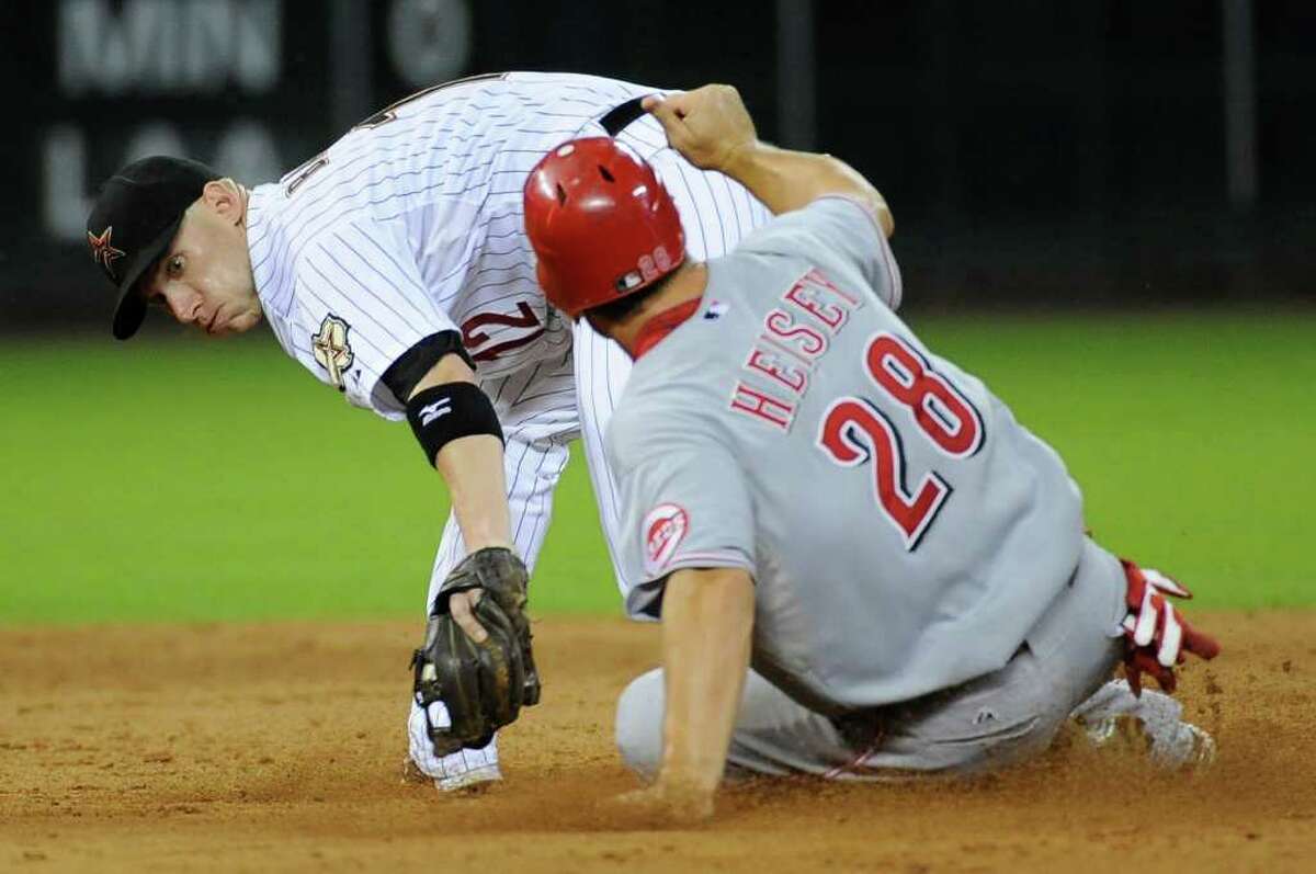 Houston Astros shortstop Clint Barmes, left, reaches for Cincinnati Reds' Chris Heisey, who steals second base in the ninth inning of a baseball game Tuesday, Aug. 2, 2011, in Houston. The Reds won 5-1.