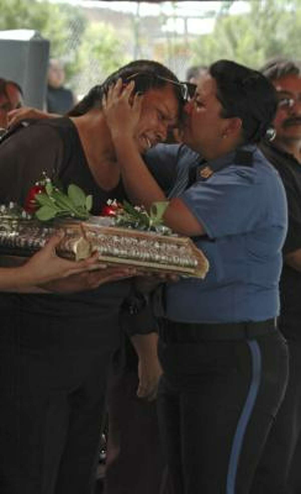 A police officer embraces an unidentified relative of policeman Jose Alan Valenzuela, during a funeral at the police station in the northern border city of Ciudad Juarez on Wednesday﻿.